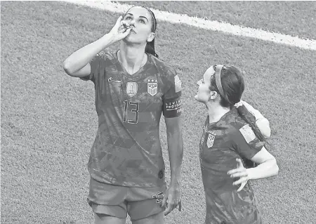  ??  ?? Alex Morgan celebrates her first-half goal as she is congratula­ted by a teammate. JEAN-PHILIPPE KSIAZEK/AFP/GETTY IMAGES