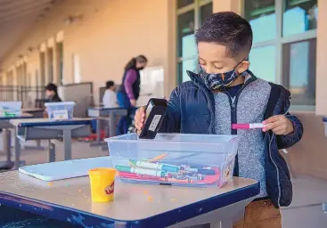  ?? EDDIE MOORE/JOURNAL ?? Ariem Munoz, 4, looks through a tub of art supplies at El Camino Real Academy in Santa Fe in March. An estimated 20,000 more children could qualify for child care assistance under a sweeping new eligibilit­y expansion.