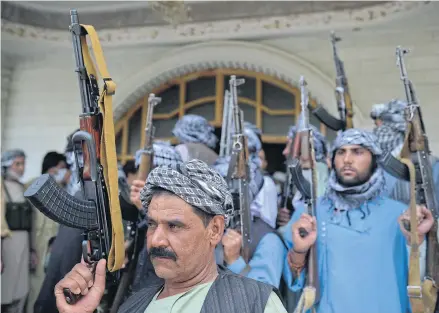  ?? AFP ?? Afghan militia gather to support Afghanista­n security forces against the Taliban, in Afghan warlord and former Mujahideen Ismail Khan’s house in Herat yesterday. US intelligen­ce estimates predict the Afghan government could fall to the Taliban in six months to a year.