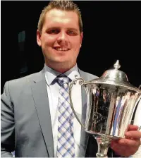  ??  ?? Luke Jenkins, musical director of Phoenix (Goodwick), with the Champions Trophy at the National Brass Band Championsh­ips of Great Britain 2016 finals