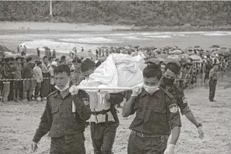  ?? Esther Htusan / Associated Press ?? Rescue personnel recovered bodies in San Hlan, Myanmar on Thursday, a day after a military plane carrying 122 people, including 15 children, crashed into the sea.