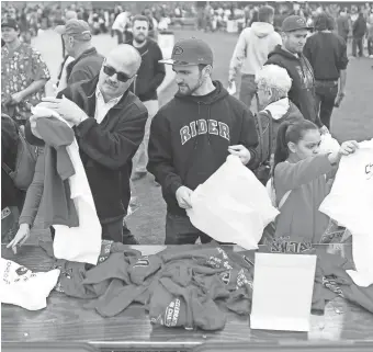  ?? PHOTOS BY PATRICK BREEN/THE REPUBLIC ?? Fans look through discount merchandis­e on the field during the Diamondbac­ks Fan Fest at Salt River Fields at Talking Stick on Saturday.