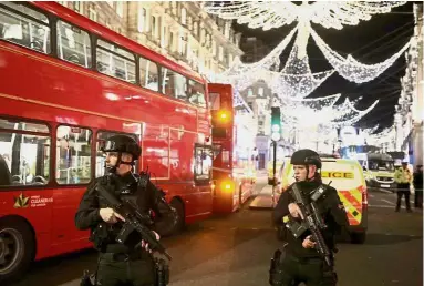  ??  ?? On high alert: Armed police officers standing guard at Oxford Street, London. — Reuters