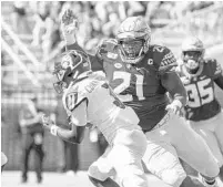  ?? MARK WALLHEISER/AP ?? Florida State defensive tackle Marvin Wilson (21) moves in for the sack of Louisville quarterbac­k Malik Cunningham (3).