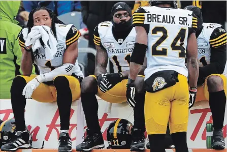  ?? SEAN KILPATRICK THE CANADIAN PRESS ?? Hamilton Tiger-Cats players, from left, Don Unamba, Larry Dean and Simoni Lawrence sit on the bench as Delvin Breaux Sr. stands by in the final moments of their season-ending loss Sunday in Ottawa. All four are pending free agents.