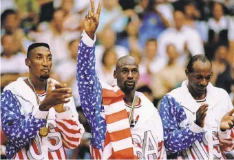  ?? MIKE POWELL/GETTY IMAGES ?? Scottie Pippen (left), Michael Jordan (center) and Clyde Drexler receive their gold medal after the USA men’s basketball team completed a dominant run through the 1992 Barcelona Games.