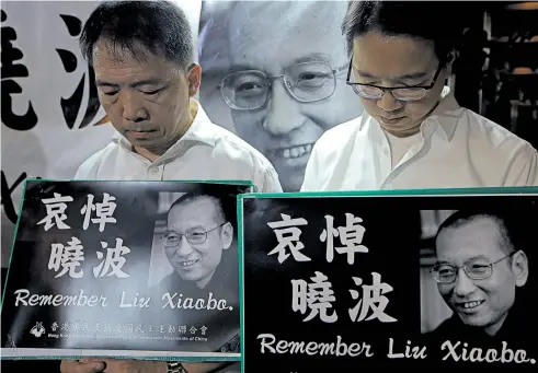  ?? Picture / AP ?? Mourners mark Liu Xiaobo’s death during a demonstrat­ion outside the Chinese Liaison Office in Hong Kong yesterday.