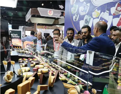  ?? Pawan Singh / The National ?? Visitors view a display of cakes at Gulfood, which opened yesterday at Dubai World Trade Centre