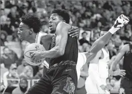  ?? LM OTERO Associated Press ?? ELIJAH McCADDEN, right, of Memphis is grabbed by Houston’s Terrance Arceneaux during the final of the American Athletic Conference tournament.