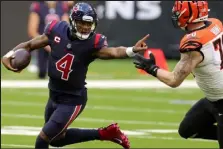  ?? Carmen Mandato / Getty Images ?? Then Texans quarterbac­k Deshaun Watson scrambles against Bengals defensive end Margus Hunt on Dec. 27, 2020 at NRG Stadium in Houston, Texas. Watson, now with the Browns, is facing a possible suspension after being sued 24 times for alleged sexual misconduct.