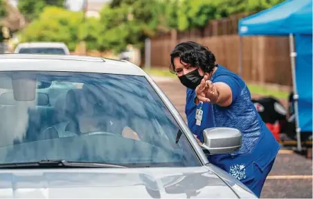  ?? Mark Mulligan / Staff photograph­er ?? Cindy Gomez, a licensed vocational nurse, points out the waiting area for people who have just received their vaccine during a vaccine drive on July 10 at the Spring Branch Community Healthcare Center.