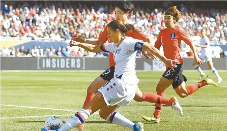  ?? AFP-Yonhap ?? Carli Lloyd, front, of the U.S. Women’s National Team takes a shot on goal while under pressure from Hong Hye-ji of South Korea during the World Cup victory tour game at Soldier Field in Chicago, Ill., Sunday.