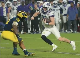  ?? RICK SCUTERI/AP ?? TCU quarterbac­k Max Duggan runs as Michigan linebacker Junior Colson defends during the second half of the Fiesta Bowl on Dec. 31 in Glendale, Arizona.