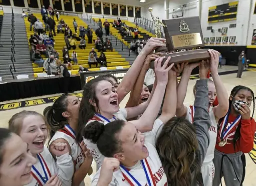  ?? Barry Reeger/For the Post-Gazette ?? Neshannock celebrates with the championsh­ip trophy after defeating Serra Catholic, 54-44, Friday at North Allegheny High School.