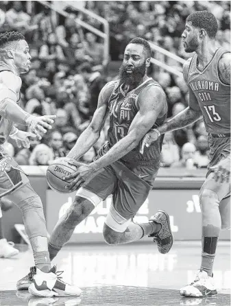  ?? Elizabeth Conley / Staff photograph­er ?? Rockets guard James Harden tries to weave between two Thunder players in the paint Saturday night. Harden extended his streak of scoring at least 30 points with 42 on 11-for 28 shooting.