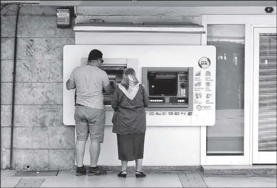  ?? REUTERS ?? People withdraw money from a bank ATM in Izmir, Turkey.