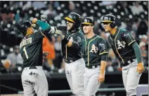  ?? Paul Sancya ?? The Associated Press Oakland Athletics second baseman Jed Lowrie, second from left, celebrates hitting a grand slam against the Detroit Tigers with Franklin Barreto (1) as Chad Pinder and Joey Wendle watch in the eighth inning in Detroit on Tuesday.