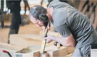  ?? ?? SKILLED: A craftsman shapes wood in the workshop of Yorkshire Oak Frames.