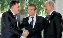  ?? PHOTO: REUTERS ?? French President Emmanuel Macron stands between Libyan Prime Minister Fayez al-Sarraj, left, and General Khalifa Haftar, right, commander in the Libyan National Army, who shake hands after talks in France over a political deal to help end Libya’s crisis.