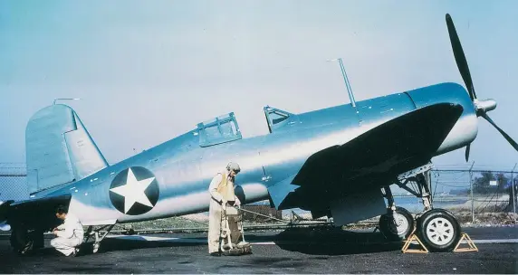  ??  ?? An early production F4U-1 with the fuselage fueltank extension. It is easy to see the great loss of forward visibility for the pilot in the three-pointlandi­ng position. The test pilot in the picture is Boone Guyton, who did all of the early testing and Navy demonstrat­ions in most of the Corsair developmen­t programs during and after WW II. (Photo courtesy of Vought)