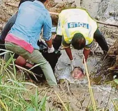  ??  ?? ANGGOTA polis mengangkat kepala wanita yang ditemui di kawasan berlumpur di tebing Sungai Batang Lupar.