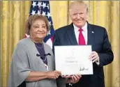  ?? ANDREW HARNIK/AP ?? Donald Trump presents a certificat­e to Minnie Grant, mother of Chris Grant, a civilian celebrated for heroism.