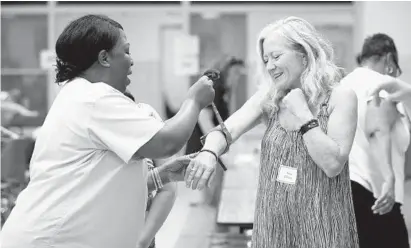  ?? JEN RYNDA/BALTIMORE SUN MEDIA GROUP ?? Pamela Smith-McNeal works with Lisa Darley, displaying how to apply a tourniquet during a training session Monday for more than 300 Anne Arundel County school nurses and health assistants. The training was held at Southern High School in Harwood.