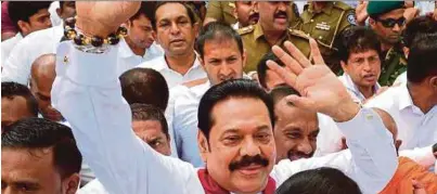  ??  ?? Mahinda Rajapakse (tengah) dia tiba di kuil Buddha terkenal di Kandy untuk mendapatka­n restu.