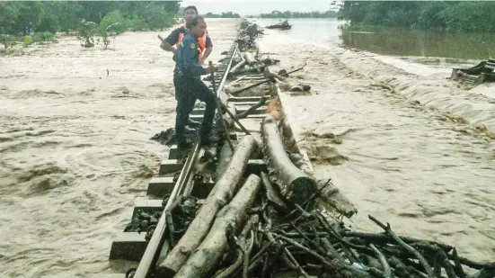  ?? HUMAS DAOP 3 FOR RADAR CIREBON ?? GANGGU PERJALANAN: Jalur kereta api Cirebon–Brebes, tepatnya di perbatasan Stasiun Ciledug Cirebon dan Ketanggung­an Brebes, terkena luapan banjir dari Sungai Cisanggaru­ng kemarin.