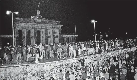  ?? FABRIZIO BENSCH/REUTERS–9/11/1989 ?? Momento histórico. Cidadãos das Alemanhas Ocidental e Oriental festejam diante do Portão de Brandenbur­go a abertura do Muro de Berlim