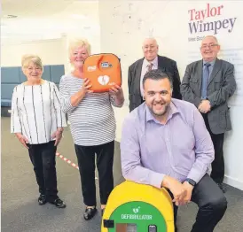  ??  ?? Giving something back Derek Schendel from Taylor Wimpey (front) delivers the defibrilla­tor to residents Liz Mcmullen, Betty Lemka and Gabe Smith, along with Councillor Coyle (second from right)