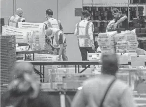  ?? CHRIS MCGRATH/ GETTY IMAGES ?? Election workers count ballots at the Philadelph­ia Convention Center on Nov. 6.