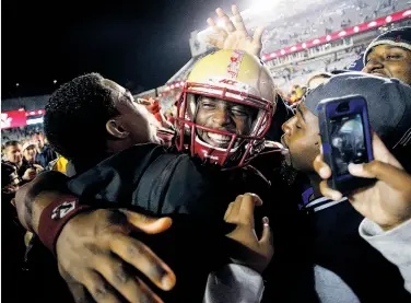  ?? Winslow Townson / Getty Images ?? Boston College quarterbac­k Tyler Murphy is swarmed after the Eagles’ 37-31 upset of USC.