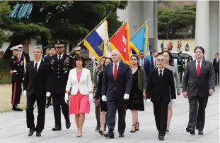  ??  ?? SEOUL: US Vice President Mike Pence (C) and his wife Karen Pence (in white jacket) inspect the honour guard upon their arrival at the National Cemetery. —AFP