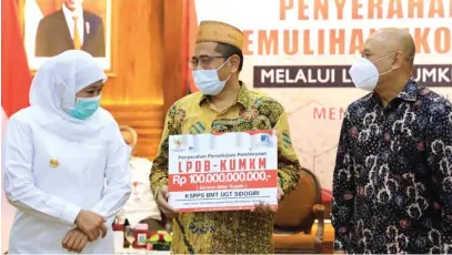  ?? PEMPROV JATIM FOR JAWA POS ?? GERAKKAN PEREKONOMI­AN: Gubernur Jatim Khofifah Indar Parawansa (kiri) bersama Menteri Koperasi dan UMKM RI Teten Masduki (kanan) secara simbolis menyerahka­n LPDB KUMKM kepada salah seorang perwakilan pelaku UMKM di Gedung Negara Grahadi, Surabaya, Rabu (30/9).