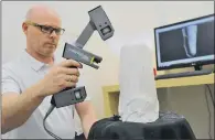  ??  ?? Steven Carter, clinical prosthetis­t, uses a laser scanner to create a 3D model of a prosthetic limb.