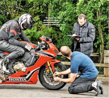  ??  ?? One holds the bike upright, one takes measuremen­ts and someone notes them down
If you’re really lucky, your bike will have an easily accessible manual adjuster for rear preload