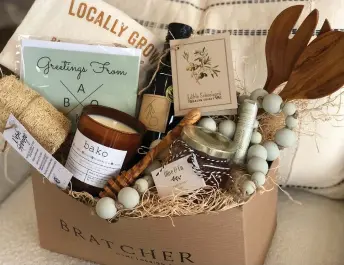  ??  ?? The Bratcher Basket includes items from several local venders, such as Edible Schoolyard's Buena Vista Extra Virgin Olive Oil, Olive & Co. and “Locally Grown” and “BAKO” merchandis­e from Kinley M. Designs.
These baskets predominan­tely started with the use of 'Locally Grown' and 'BAKO' merchandis­e designed by Kinley M. Designs, paired with unique Bratcher Home kitchen accessorie­s, such as a mini cheese board with spreader and a mini glass honey pot. The baskets quickly evolved into somewhat of a local vendor buzz, incorporat­ing suitable inventory scaled and priced properly for a gift basket."