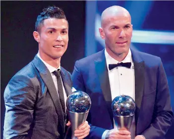  ?? — AFP ?? Real Madrid’s coach Zinedine Zidane (right) stands with his Best Fifa men’s coach trophy alongside Cristiano Ronaldo, who won the Best Fifa men’s player award in London on Monday.