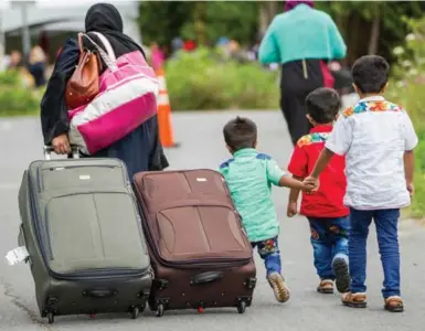  ?? GEOFF ROBIN/AFP/GETTY IMAGES FILE PHOTO ?? Asylum seekers walk along Roxham Road near Champlain, N.Y., making their way toward the Canadian border.