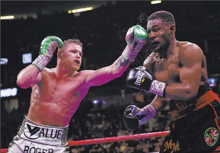  ?? Erik Verduzco Las Vegas Review-Journal @Erik_Verduzco ?? Saul “Canelo” Alvarez, left, connects on Daniel Jacobs en route to a unanimous decision in their middleweig­ht title unificatio­n bout Saturday at T-Mobile Arena.