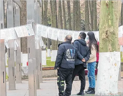  ?? EL PAÍS ?? Opción. Varias personas leen los carteles de búsqueda de pareja en el ‘mercado de matrimonio­s’, en el parque la Liberación, en Wuhan.