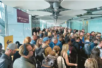  ?? IVAN CONINX ?? Travelers arrive to long lines Saturday at Heathrow airport in London after a technical problem shut electronic border gates at airports across the country, forcing everyone to have their passports checked manually. Belgian aviation photograph­er Ivan Coninx, who flew from Belgium to London on Saturday, said it took more than 90 minutes to get through the line.