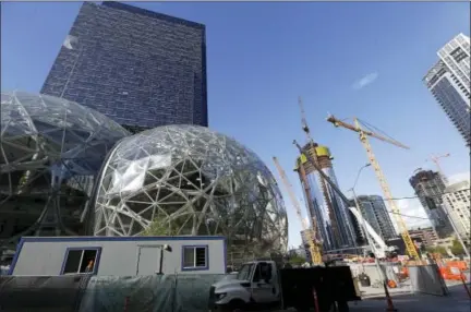  ?? ELAINE THOMPSON — THE ASSOCIATED PRESS FILE ?? On Oct. 11, 2017, large spheres take shape in front of an existing Amazon building, behind, as new constructi­on continues across the street in Seattle. Amazon announced in 2017 it is looking for a home for its second headquarte­rs.