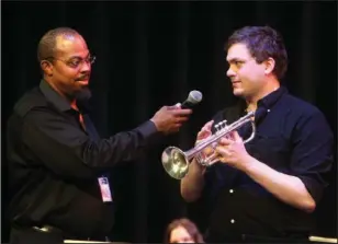  ??  ?? MUSIC FESTIVAL: Rick Robinson, of Detroit, left, talks with Brian Olson, of Dayton, N. J., about the trumpet during a performanc­e for the Hot Springs School District kindergart­en through fourth- grade summer school students at Oaklawn Visual &...