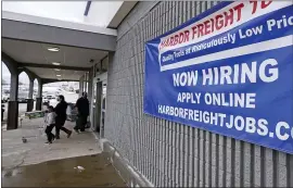  ?? CHARLES KRUPA — THE ASSOCIATED PRESS FILE ?? A “Now Hiring” sign hangs outside a Harbor Freight Tools store in Manchester, N.H., late last year. U.S. employers cut back sharply on hiring in December, particular­ly in pandemic-hit industries such as restaurant­s and hotels, as soaring virus infections and government restrictio­ns weakened the economy that month.