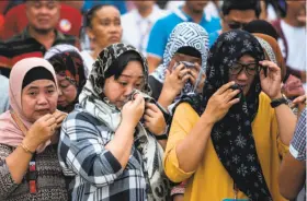  ?? Noel Celis / AFP / Getty Images ?? Residents of Marawi in the southern Philippine­s weep during an Independen­ce Day ceremony dedicated to those slain in the siege of the city by militants.
