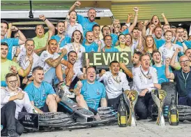  ?? /AFP ?? Winning team: Lewis Hamilton celebrates with his team after winning the Abu Dhabi Grand Prix on Sunday. Rumour has it he could be lured to drive for Ferrari next season.