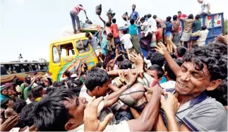  ??  ?? Rohingya refugees scuffle as aid is distribute­d in Cox’s Bazar, Bangladesh, on Saturday. (Reuters)