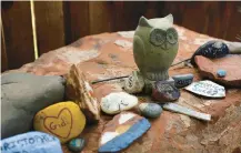  ?? ?? Painted rocks and objects to remember lost loved ones are laid out at a quiet space at the farm.